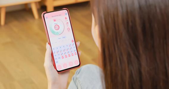 Person looking at ovulation app on their smartphone