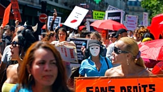 عاملة جنس في فرنسا تحمل لافتة كتب عليها «بدون حقوق» في مسيرة في باريس، 2 يونيو 2011