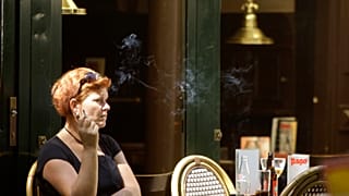 امرأة تدخن خارج حانة في وسط أمستردام، هولندا، الثلاثاء 1 يوليو 2008. 