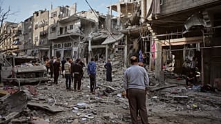 يتفقد فلسطينيون أنقاض منزل عائلة إسماعيل الذي دمرته غارة إسرائيلية على مخيم المغازي.