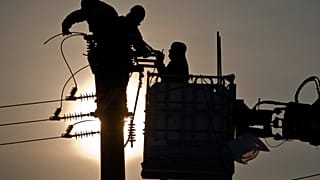 موظفو شركة التوزيع الوطنية للكهرباء يُصلحون خطوط الكهرباء المتضررة من العواصف الثلجية قرب بيتوليتشا في رومانيا، الأربعاء، 15 فبراير 2012.