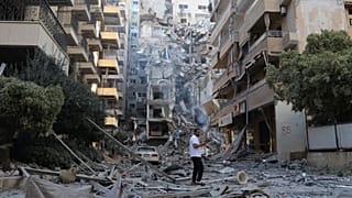 رجل يتفقد موقع مبانٍ مدمرة استهدفتها غارات جوية إسرائيلية في مدينة صور الساحلية جنوب لبنان