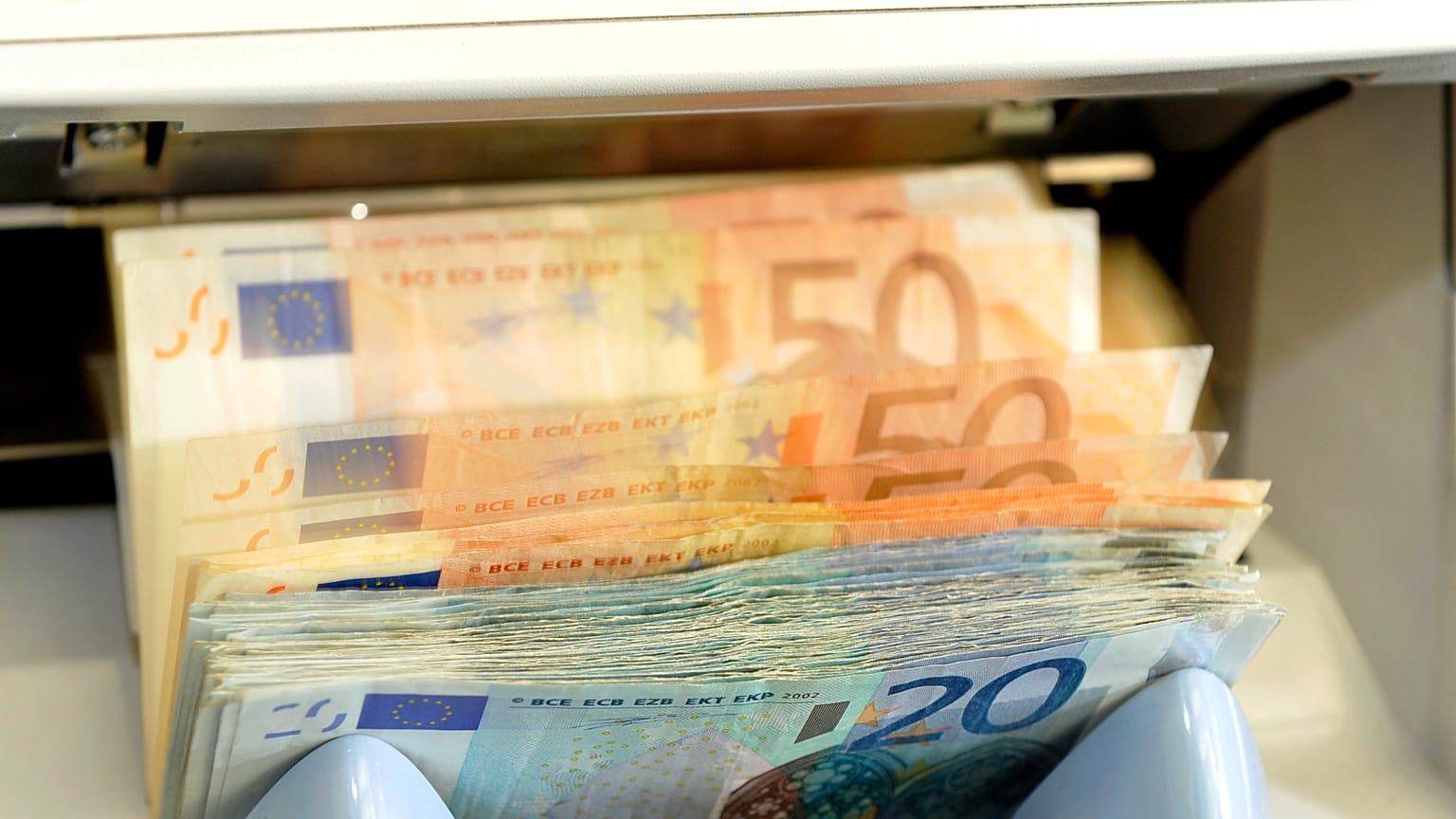 أرشيف - في صورة مؤرخة في 22 يونيو 2009، آلة تعد أوراق عملة "اليورو" في شباك أحد البنوك في مدينة دريسدن الألمانية.
