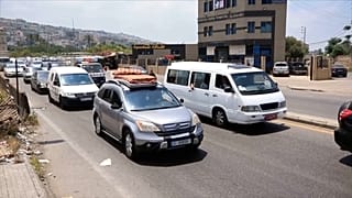 سيارات عالقة في الازدحام تحمل أمتعة وحيوانات أليفة ومراتب