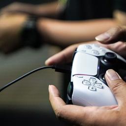 Jemand spielt mit einem Playstation-Controller