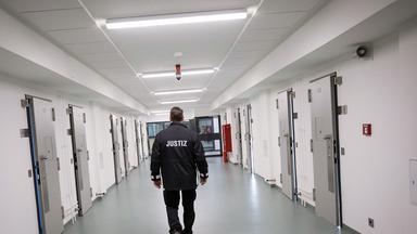 Ein Justizbeamter patrouilliert über einen Gefängnisflur