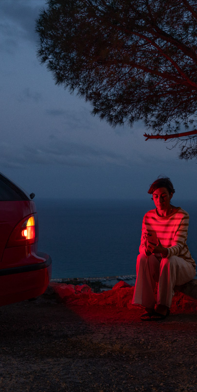 Photo of a woman next to an SUV that has broken down.