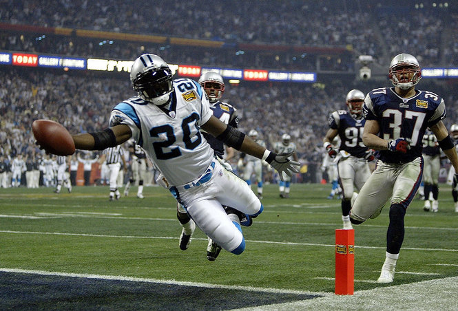 Even with billions in American Football, the game has not crossed America's borders. Here is Running back DeShaun Foster (20) of the Carolina Panthers scores on a 33 yard touchdown run against the New England Patriots during Super Bowl XXXVIII at Reliant Stadium on February 1, 2004 in Houston, Texas. | Getty Images File Photo