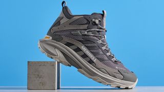 A photo of the Merrell Moab Speed 2 boots against a blue background