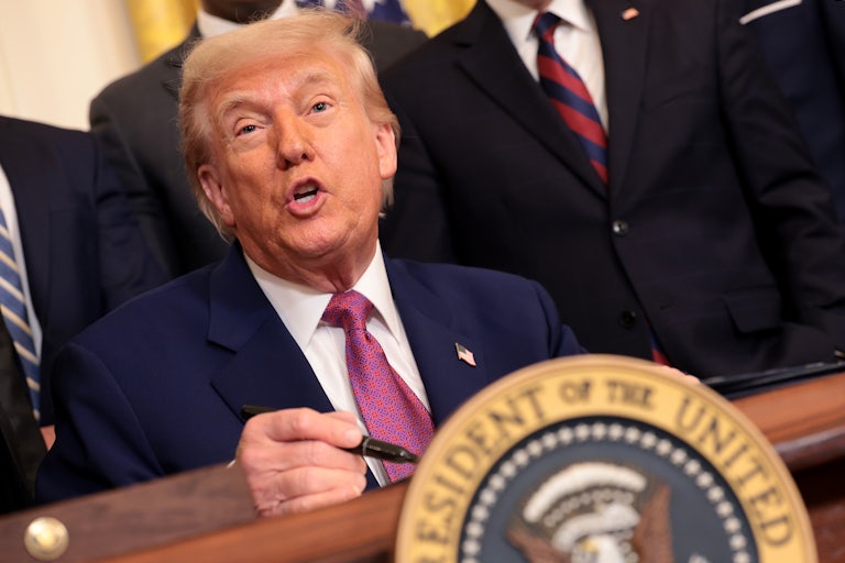 Donald Trump sits at his desk in the White House.