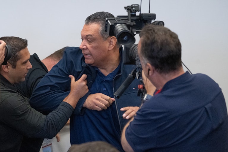 Multiple men push Democratic Senator Alex Padilla out of Homeland Security Secretary Kristi Noem's press conference. A cameraman captures it all.