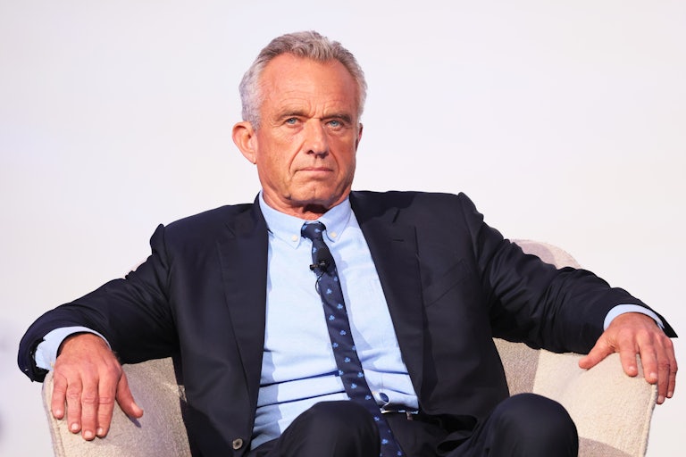 Robert F. Kennedy Jr. sits in a chair in a menacing way