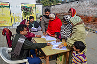 Uttar Pradesh Publishes Draft Electoral Roll After SIR, 2.89 Crore Names Excluded | Photo: PTI : People search for their names in the draft voter list after the Special Intensive Revision of electoral rolls in Uttar Pradesh, in Mirzapur, Uttar Pradesh.