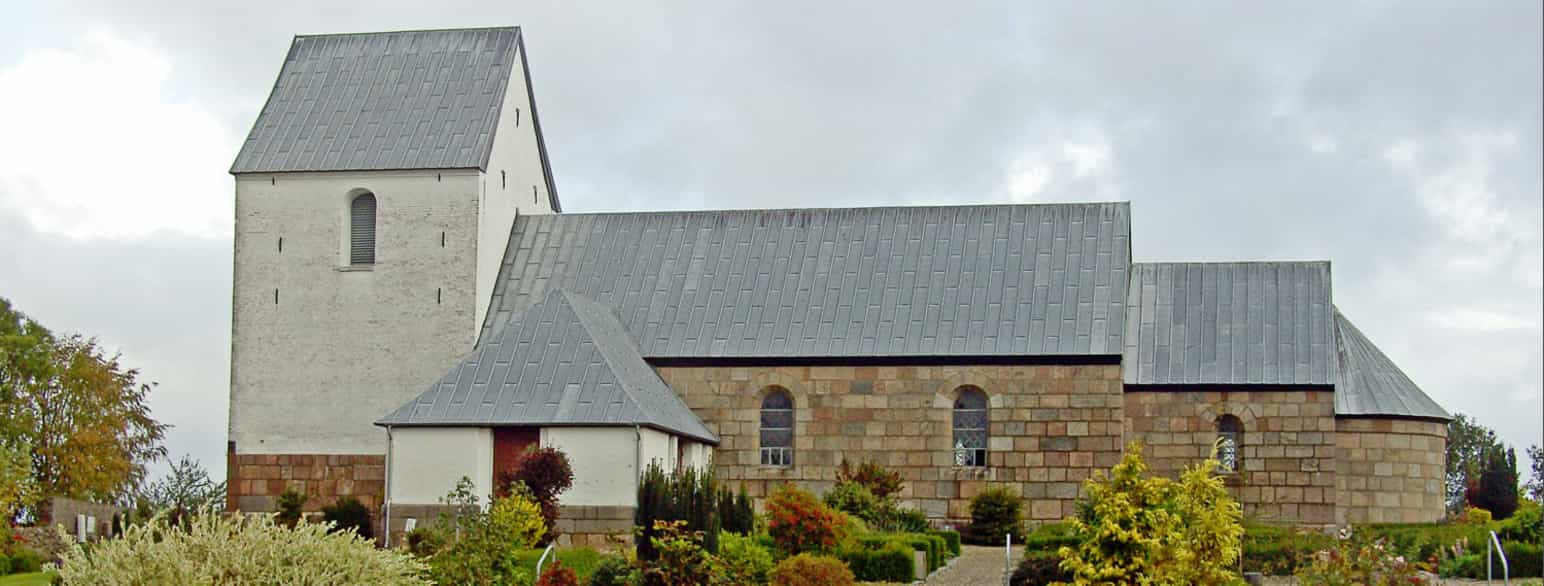 Hammershøj Kirke set udefra. Kirkens romanske bygningsdele står i blank mur med synlige byggematerialer, mens de senere tilbygninger, tårn og våbenhus, er hvidkalkede. 