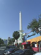 Side view of the Alex Theatre and the 100-foot-tall (30 m) art-deco column with neon lights, topped by a spiked, neon sphere that gave it a "starburst" appearance (2014)