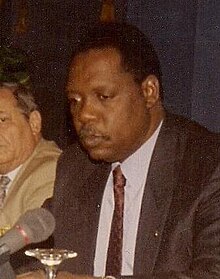 A seated Hayatou speaking into a microphone