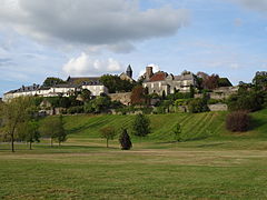 Vue générale d'un village, au premier plan un pré.