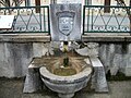 Fontaine avec le blason de Barbazan devant la mairie.