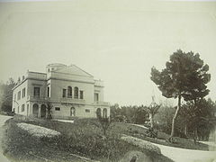 Le Plantier de Costebelle en 1863, le parc encore vierge de plantations, fiacres visibles sur la droite de la maison. Sur la droite de la photographie, un grand pin d'Alep. Les allées en gravillon et une chapelle dans le bois de pins bas sont visibles. Quelques jeunes Phoenix dactiliferas sont plantés.