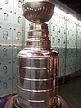 The cup with the plaques belonging to members of the Hockey Hall of Fame in the background.