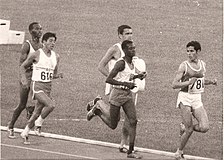 Auf der Gegengeraden vor Beginn der vorletzten Runde: Mohamed Gammoudi (rechts) vor Naftali Temu (Zweiter von rechts.), dahinter Ron Clarke noch auf Platz drei vor Juan Martínez und Kipchoge Keino (ganz links)