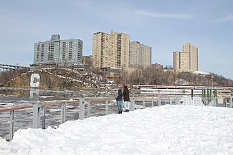 Boat dock and deck covered in snow, with Columbia "C" on opposite bank.