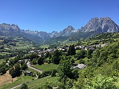 Vue générale sur un village et un cirque naturel au second plan.