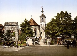 Photographie en couleurs d'un ensemble composé d'une église et d'un monument antique.