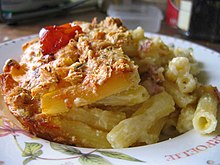 Plat de pâtes gratinées avec de la sauce tomate et une tomate-cerise