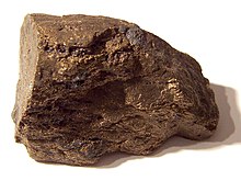 A brown block of irregular shape and surface, about 6 см in size.