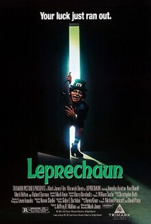 Actor Warwick Davis, dressed in heavy make-up as a leprechaun, opens a door and lights up a dark room