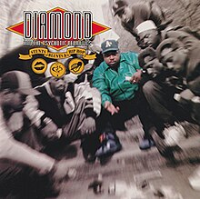 A photo of Diamond D playing dice with a group of men on a street. The photo is mostly monochrome and is slightly blurred. It is focused on Diamond D, who is located in the middle and is the only person colored. In the top left corner there is the "Diamond and the Psychotic Neurotics" logo, a yellow ribbon with the album's title, and three small yellow pictures, showing lips, smoke, and a microphone.