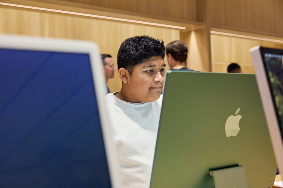 Seorang pelanggan menjelajahi rangkaian Mac terbaru di Apple Miami Worldcenter.