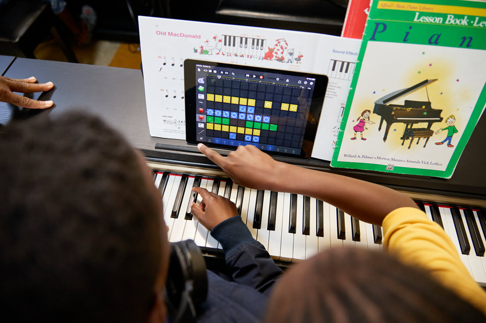 Para siswa menggunakan iPad di piano mereka saat mengikuti kelas piano di Ellis Marsalis Center.