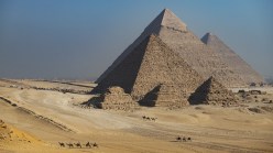 Several ancient pyramids in a desert.