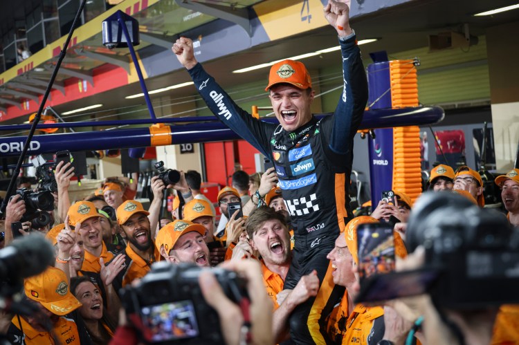 Lando Norris celebrates his F1 World Drivers Champion title with his team in Abu Dhabi.